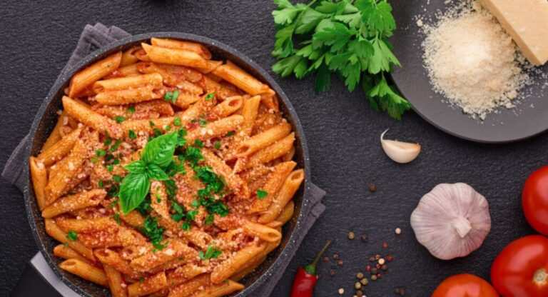 Baked Mannacote with golden melted cheese, creamy ricotta filling, and rich tomato sauce served on a white plate